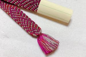 ピンクと白の糸で編まれた帯締めの両端