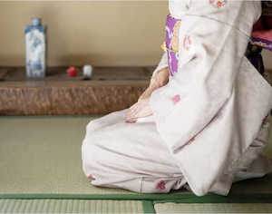 畳の上で正座する着物姿の女性